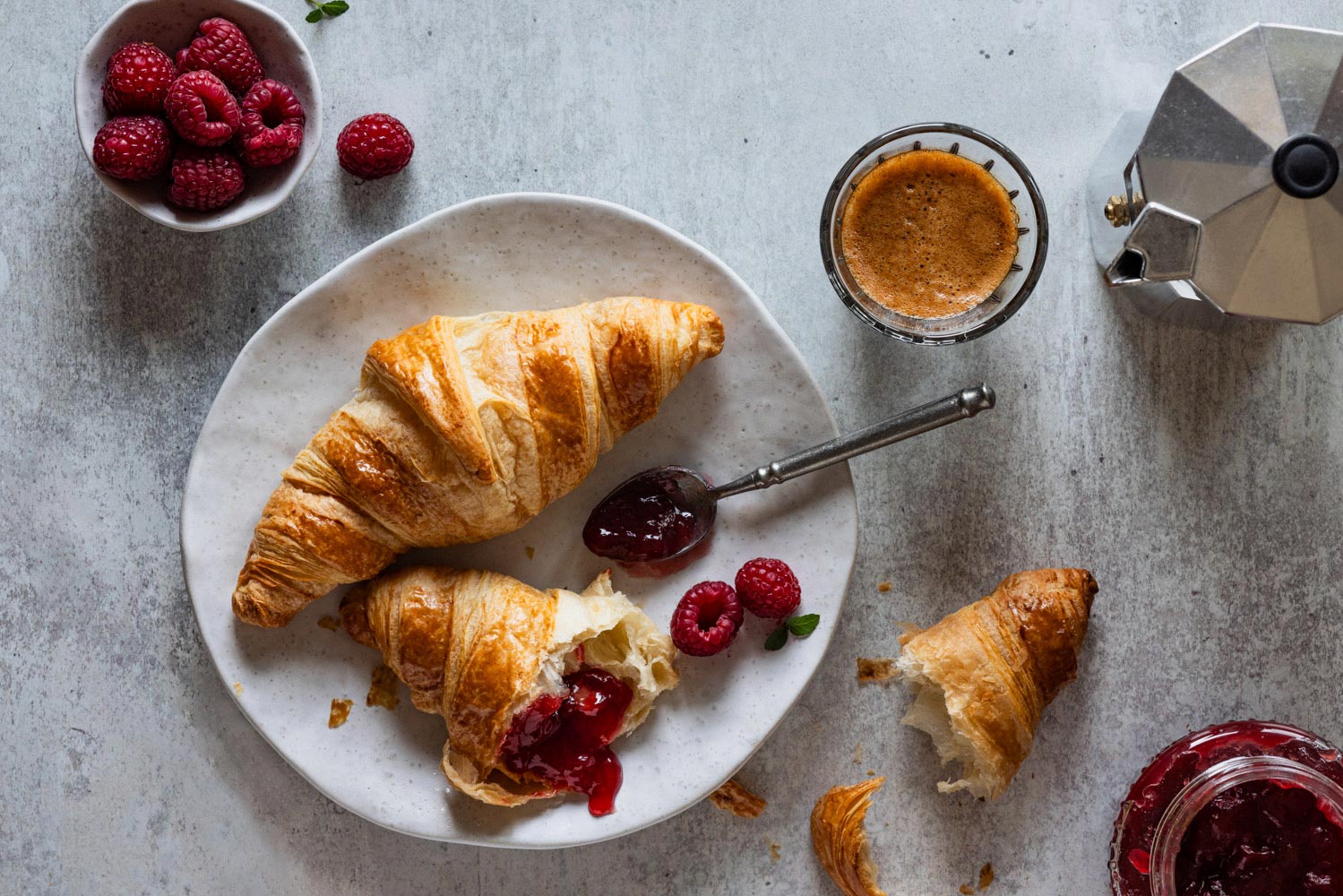 Croissants mit Himbeermarmelade und Kaffee.