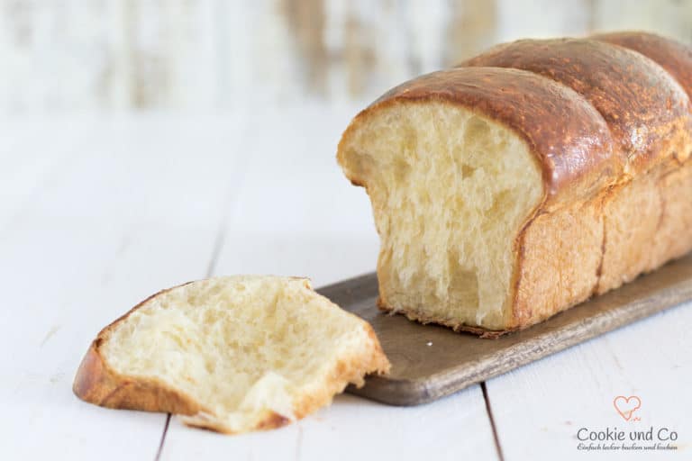 Französische Brioche angeschnitten auf einem Holzbrett.