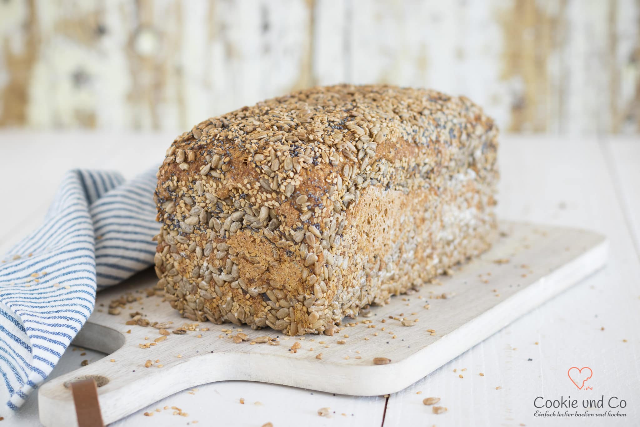 Dinkel-Möhren-Vollkornbrot mit Saaten auf einem Holzbrett.