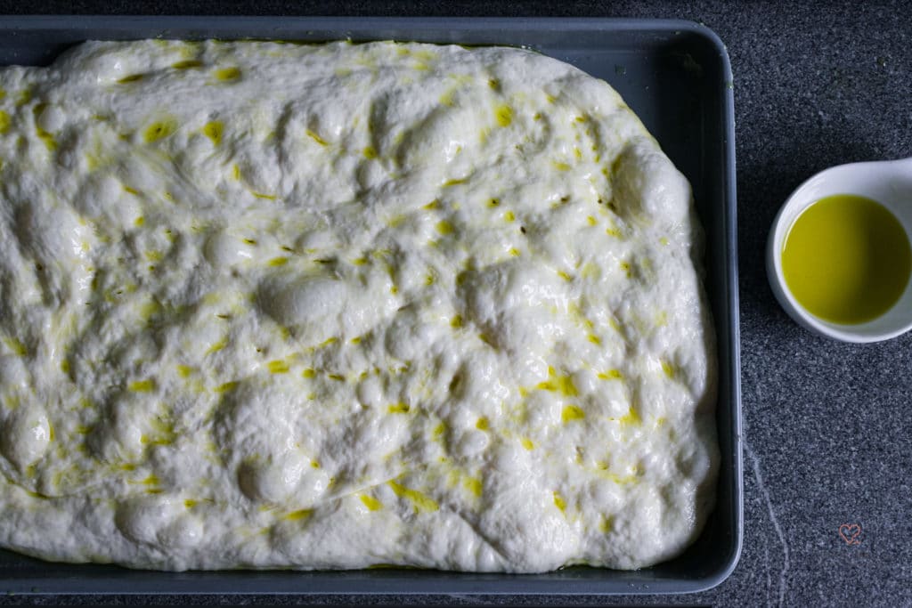 Teig für Focaccia auf einem Blech mit Olivenöl