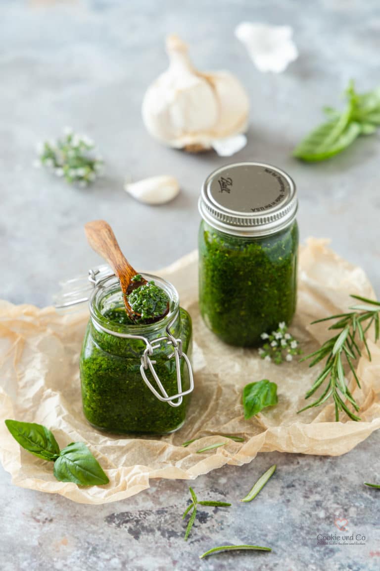 mediterrane Kräuter-Gewürz-Paste in einem Glas und auf einem Holzlöffel