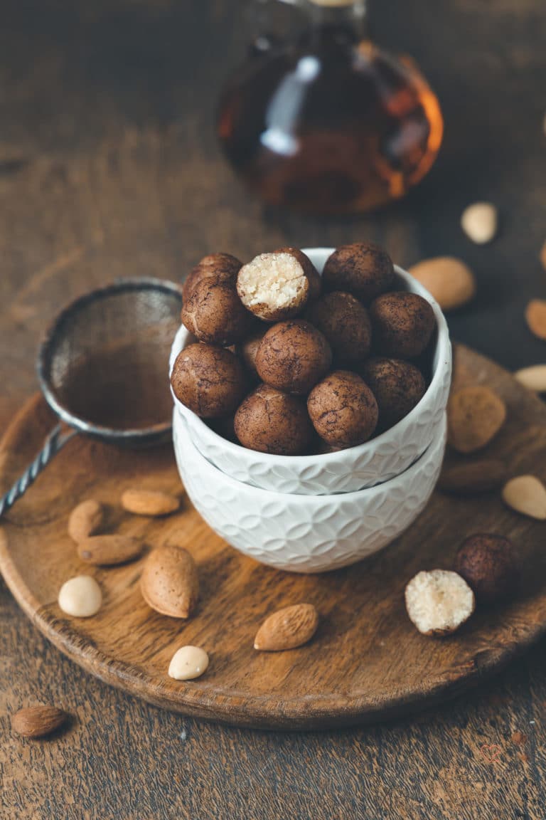 Marzipankartoffeln mit Mandeln und Amaretto im Hintergrund