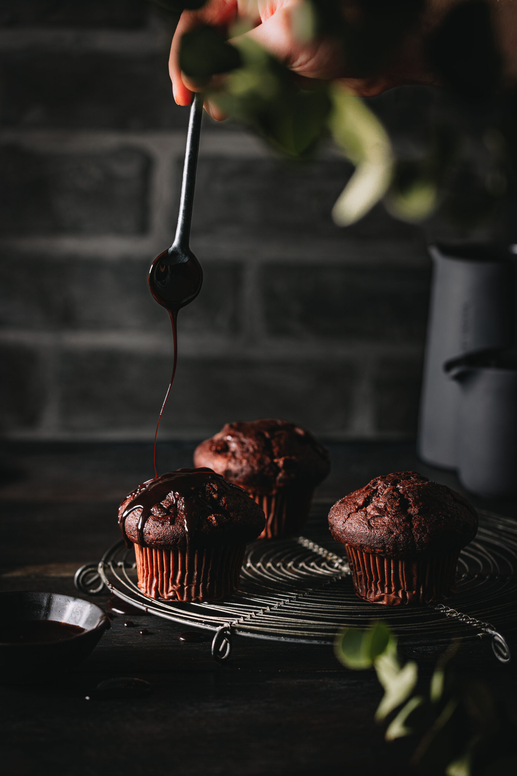 Schokoladenmuffins mit einer ausgepusteten Kerze auf einem Kuchengitter.