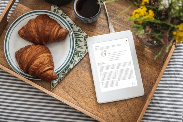 E-Book For the love of bread auf einem Kindl auf einem Holztablett mit Croissants und Blumen daneben.